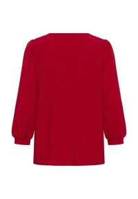 Rode shirt met lange mouwen, een ronde halslijn, geplooide schouders en elastische manchetten. De stof heeft een subtiele textuur en een gladde afwerking.