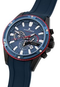 Blå kronografklocka med en rödaccentuerad bezel, svart urtavla och ett blått gummiremm. Har tre subdials och datumvisning. Vattentålig upp till 20 ATM.