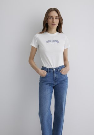 White short-sleeve t-shirt with "CAT MOM" graphic text in blue, paired with high-waisted blue denim jeans featuring a straight leg fit.