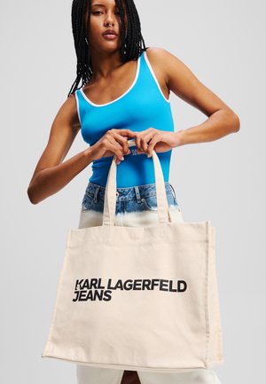 Borsa tote in tela beige con "KARL LAGERFELD JEANS" in grassetto nero. Presenta manici robusti e un design semplice e spazioso.