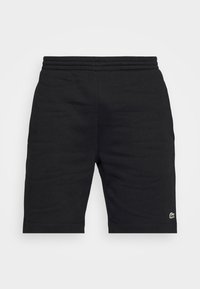 Pantaloni corti neri in cotone con elastico in vita, caratterizzati da un piccolo logo verde Lacoste sul lato sinistro in basso. Texture liscia e design semplice.