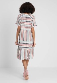 Gestreiftes Kleid mit gestuftem Rock, in Pastellfarben Rot, Blau und Creme. Kurze Ärmel und Details mit gerafftem Halsausschnitt.