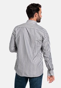 Knoop-up shirt met smalle marineblauwe en witte strepen, lange mouwen, afgeronde zoom en een klassieke kraag, gemaakt van een lichtgewicht stof.