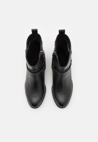 Bottines noires en cuir lisse, avec une fermeture éclair, une bande texturée et un design de bout rond. Intérieur doublé doux.