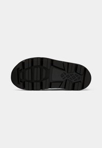 Black rubber sneaker sole with a rugged tread pattern. Features grooves and varying section heights for traction and flexibility.