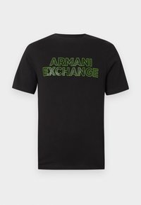 Μαύρο T-shirt με κοντά μανίκια, με το κείμενο "ARMANI EXCHANGE" περιγραμμένο με νέον πράσινο χρώμα στο στήθος, σε απλό λευκό φόντο.