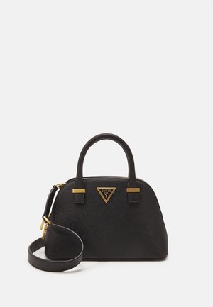 Czarna torebka z teksturą, z dwoma uchwytami, odpinanym paskiem na ramię i złotym, trójkątnym logo Guess z przodu na jednolitym białym tle.