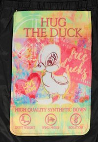 Syntetyczna puchowa torba z kolorowym, tie-dye tłem. W centralnej części znajduje się rysunkowa kaczka i tekst oraz ikony przedstawiające cechy produktu.