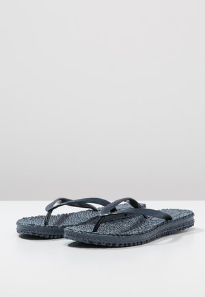 Pair of dark blue woven flip-flops with textured soles and thin glittery straps resting on a white surface.