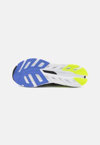 Shoe sole featuring a white base, blue and bright yellow accents, textured grip, and cut-out sections for improved flexibility.