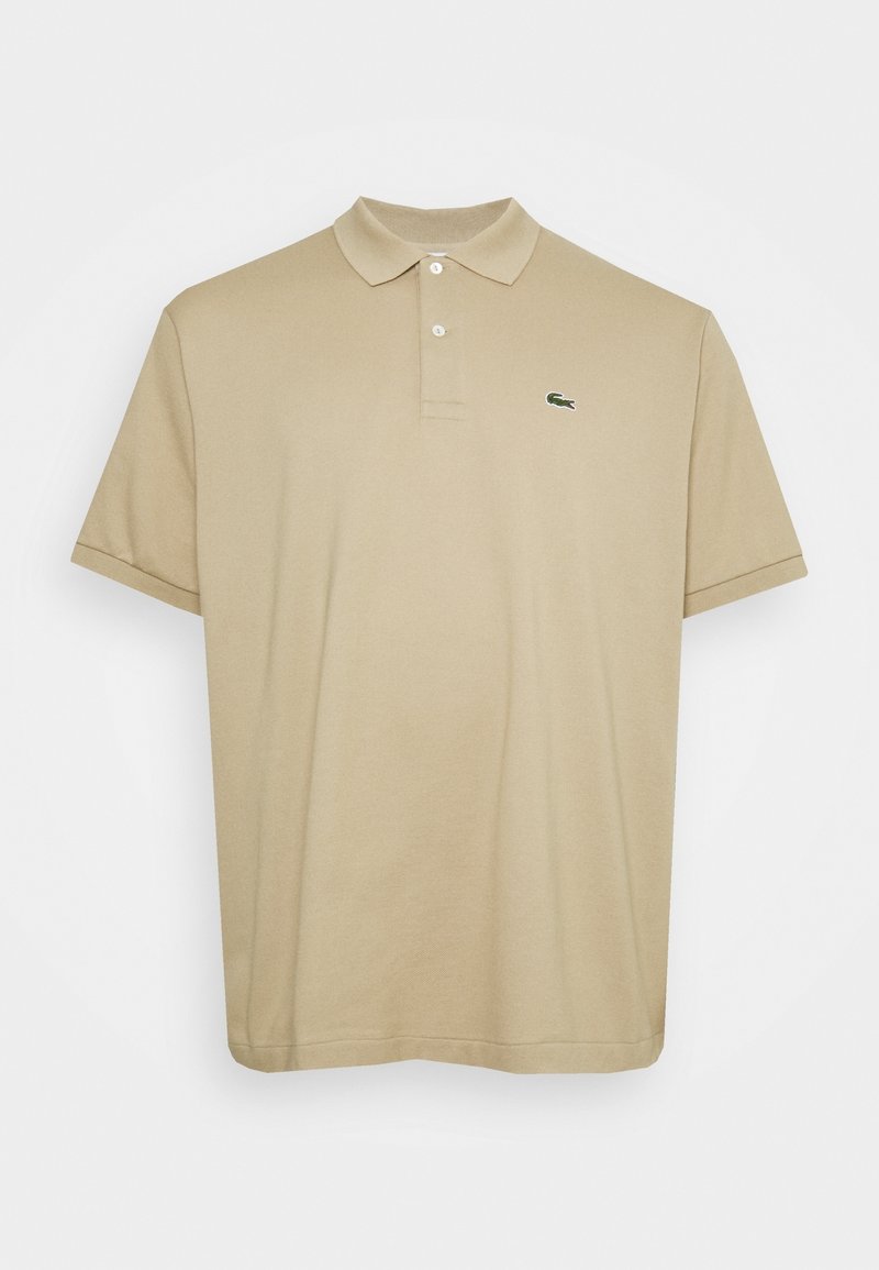 Polo beige en coton avec un col, des manches courtes et un logo vert brodé sur le côté gauche de la poitrine. Texture lisse.