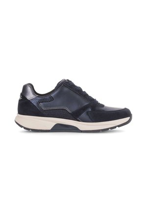 Black low-top sneaker with mixed leather and suede panels, cream cushioned sole, and black laces, shown in side profile on white background.