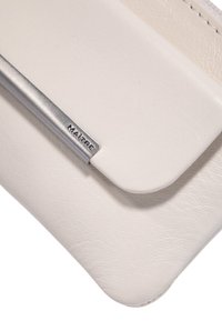 Hvid læderpung med en sølvmetal akcent. Designet er slankt med en diskret lukning og glat tekstur.