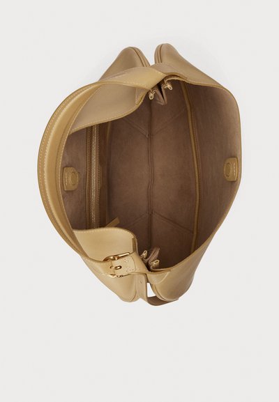 Zlatna torba od kože s prostranim unutrašnjim dijelom obloženim brušenom kožom, s džepom na zatvarač i glatkim, zaobljenim rubovima. Uključeni su kratki ručkovi.