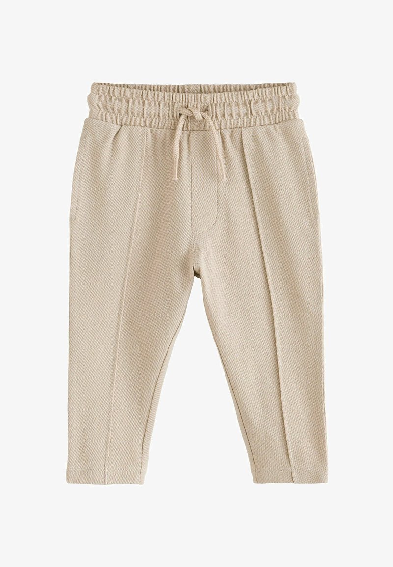 Pantaloni beige testurizzati per bebè con vita elastica e coulisse frontale, con tasche laterali e pieghe cucite sulle gambe.