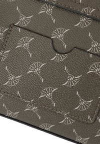 Billetera de textura gris con un sutil patrón blanco que asemeja flores estilizadas, que cuenta con un compartimento para tarjetas y costuras negras a lo largo de los bordes.
