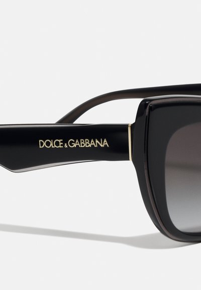 Black rectangular sunglasses with gradient lenses. Features gold logo on the side and a sleek, glossy finish. Sturdy frame design.