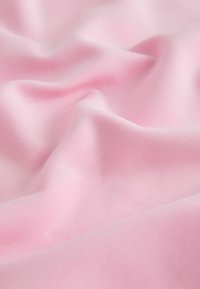 Svetloružová látka s hladkou textúrou, ktorá zobrazuje jemné záhyby a konzistentný povrchový vzor. Vhodná pre rôzne textilné aplikácie.