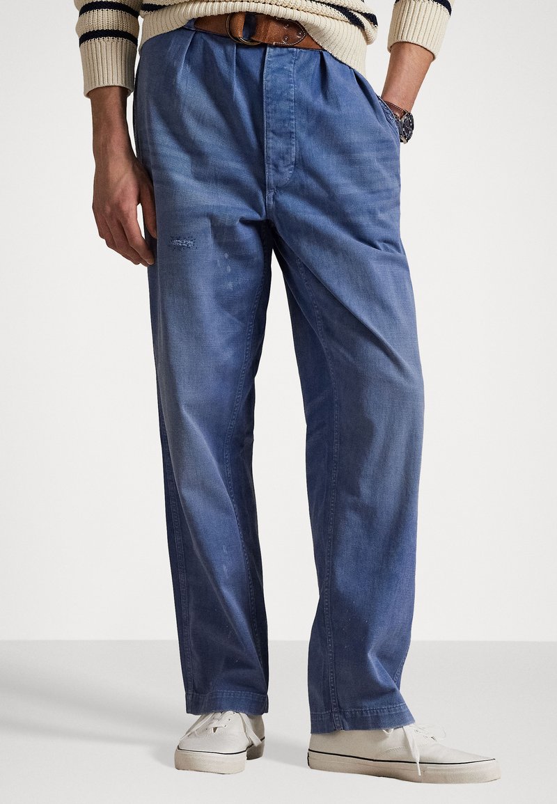 Hellblaue Jeanshose mit lockerer Passform, ausgestattet mit vorderen Falten, zwei Seitentaschen und dezenten Used-Effekten im Stoff.