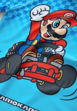 Modré plavky s grafikou postavičky v motokáre, s červenými a hnedými detailmi, čiernymi kolesami a farebným šachovnicovým pozadím.