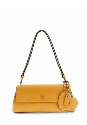 Sac à bandoulière jaune moutarde avec une sangle bordée de noir, logo triangulaire Guess et breloque en forme de cœur attachée.