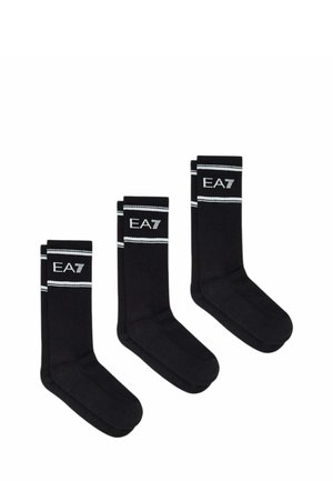 Tre paia di calzini neri crew con strisce bianche e testo "EA7" vicino alla cima, mostrati uno accanto all'altro su sfondo bianco.