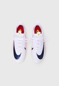 Scarpe atletiche bianche con una texture liscia, logo swoosh navy, accenti rosa sulla suola e fodera interna rossa. Design con lacci e linguetta per il tallone.