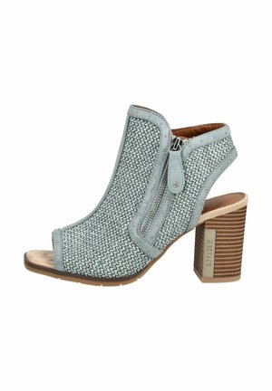 Lyseblå vævet sandal med åben tå, hæl med stablet træblok og side lynlås på hvid baggrund.