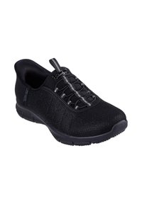 Zapatilla negra con parte superior de malla texturizada, sistema de cordones elásticos y suela acolchada. Cuenta con una lengüeta en la parte posterior para ponérsela fácilmente.