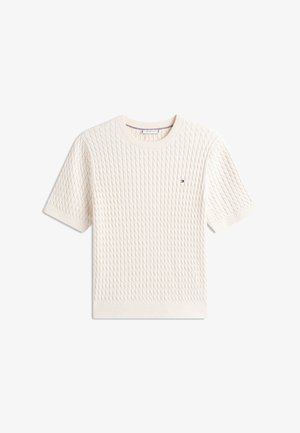 Pull en maille crème à manches courtes avec motif torsadé texturé et petit logo drapeau sur la poitrine.