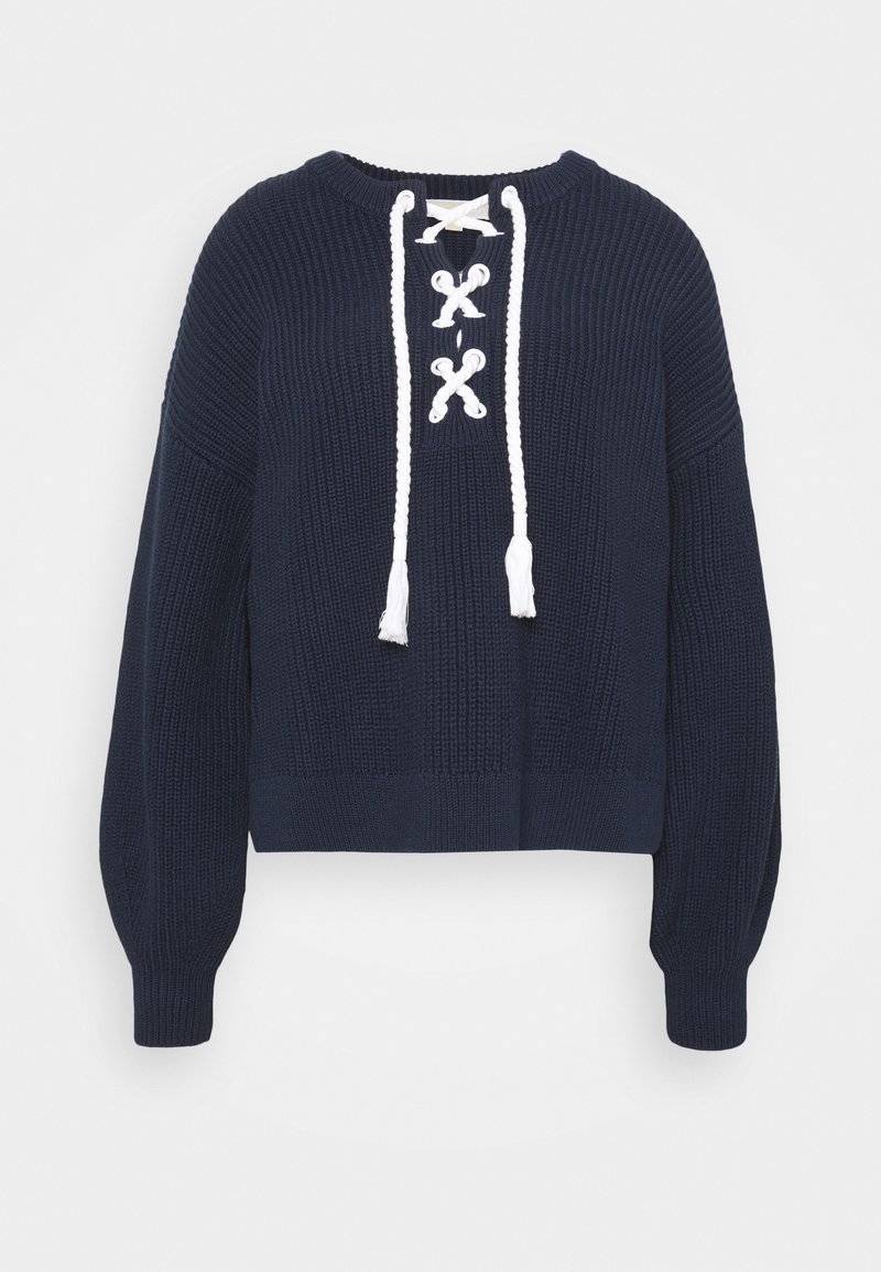 Maglione lavorato a maglia blu navy con un design cropped, scollatura rotonda e dettaglio bianco con lacci sul davanti che presenta dei pon-pon alle estremità.