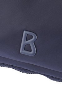 Borsa in tessuto blu navy con un logo "B" grigio in rilievo. Il materiale è testurizzato, con bordi lisci e dettagli con zip lungo il bordo.