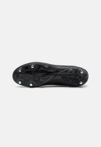 Sort sportsko sål med formet gummi, seks metalstifter for greb, tekstureret overflademønster, letvægtsdesign og aerodynamisk form.