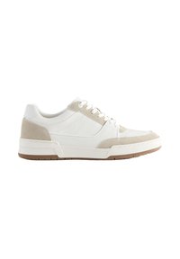 Baskets basses blanches avec des accents en daim beige, lacets blancs et semelle en caoutchouc marron vues de côté sur fond blanc.