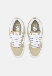 Beige suede sneakers with white laces, a white side stripe, and a textured beige toe cap. Features Vans logo on the tongue and insole.