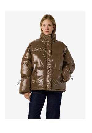 Un mannequin se tient devant un fond blanc portant une doudoune marron brillante oversize avec un col montant et un jean foncé.