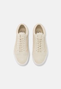 Beżowe trampki wykonane z teksturowanej tkaniny i zamszu. Posiadają pleciony detal po bokach, białą gumową podeszwę oraz klasyczne wiązanie na sznurówki.