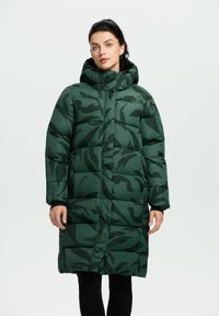 Abrigo largo verde acolchado con capucha, que presenta un patrón de camuflaje oscuro, textura acolchada y cierre frontal con cremallera.