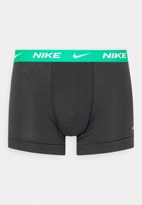 Boxer neri con elastico verde in vita e logo Nike in bianco. Realizzati in tessuto elastico, con apertura frontale e dettagli delle cuciture.