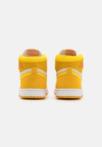 Des baskets montantes en suède jaune vif avec des accents blancs et des semelles en caoutchouc. Dotées d'un logo sur le talon et d'un col rembourré pour plus de confort.