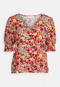 Blusa floral com decote em V, mangas curtas e bufantes, feita de tecido leve, apresentando um padrão multicolorido de vermelhos, amarelos e verdes.