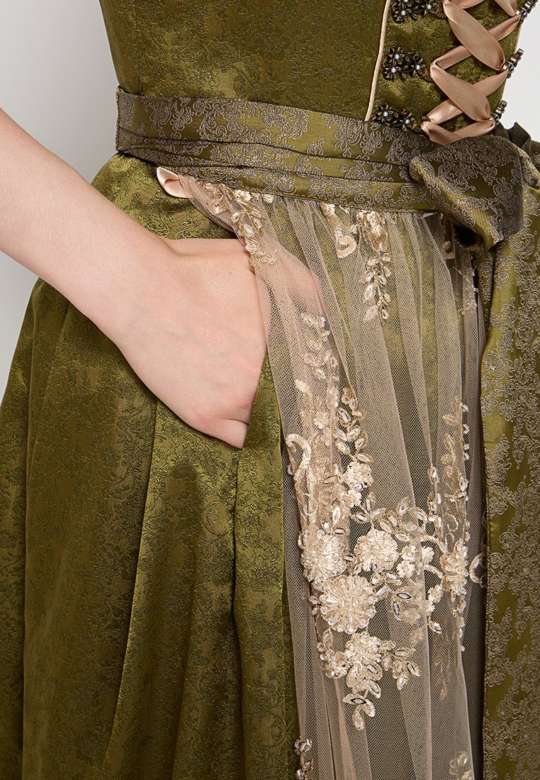 Grünes Kleid aus strukturiertem Stoff, mit Spitze überzogen und floralem Stickdesign, sowie einem satinierten Taillenbund mit einer versteckten Tasche.