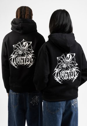 Black hoodies with a large white spider graphic and "WASTED" text on the back; denim pants feature a smaller spider design on the pockets.