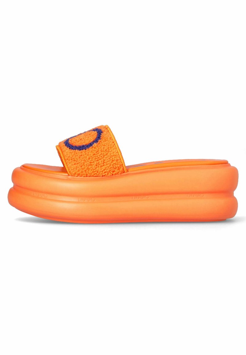 Sandale mule à plateforme orange vif avec semelle épaisse et bride en tissu texturé ornée d'un motif circulaire bleu.