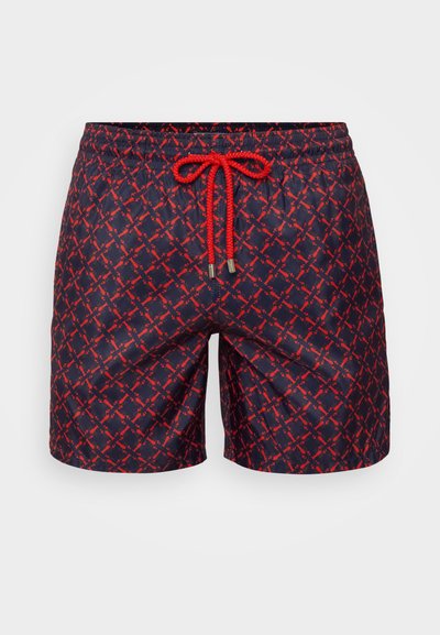Navy swim shorts with a red geometric pattern, elastic waistband, and contrasting drawstring. Lightweight material with a smooth texture.