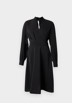 Vestito nero con profondo scollo a V, maniche lunghe a sbuffo e vita aderente. Realizzato in tessuto morbido, presenta una gonna fluente e pieghe sottili.