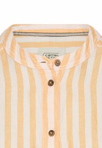 Gestreepte shirt in lichtgeel en wit, met een ronde kraag, twee houten knopen en een label met de tekst "Camel Active."