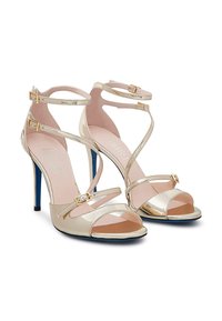 Sandali con tacco alto e cinturini in pelle verniciata oro metallico con punta aperta, dotati di una fodera interna rosa e tacco blu. Con fibbie regolabili.