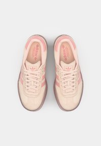 Helle rosa Wildledersneaker mit drei dunkleren rosa Streifen, runder Zehenform und Schnürdesign. Gummisohle mit strukturierten Details.