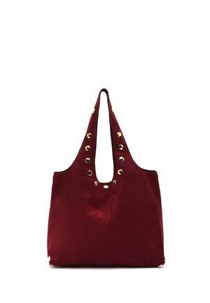 Grand sac cabas bordeaux avec des anses larges et des clous dorés décoratifs le long des bords et des ouvertures des anses.